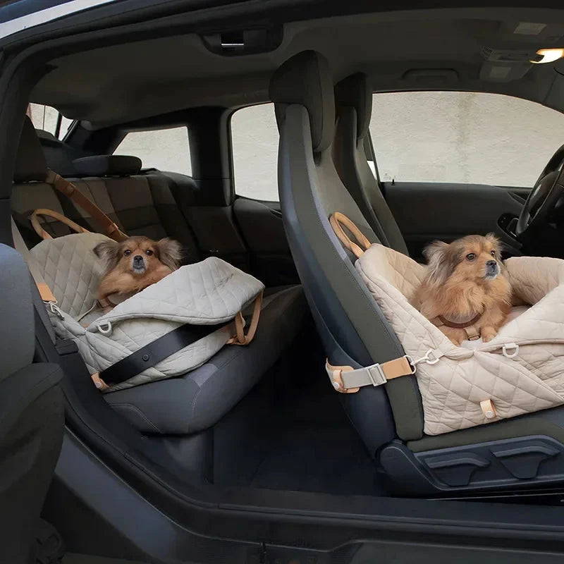 Two dogs in pet seats with blankets inside a car.