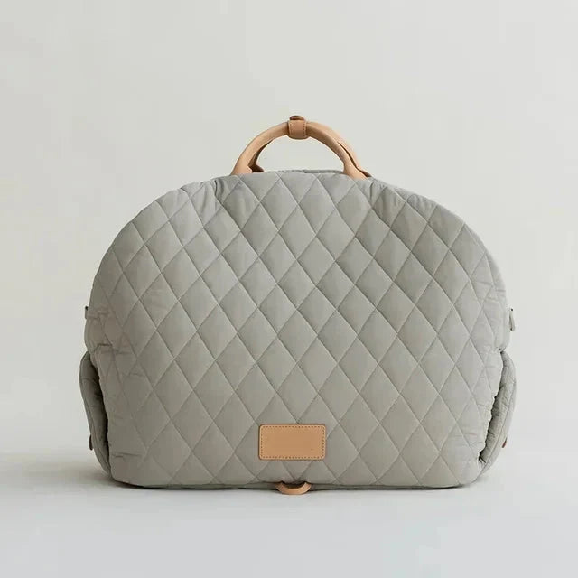 Quilted gray bag with wooden handle on a light gray background