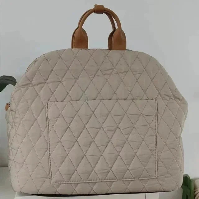 Beige quilted bag with brown handles on a white background