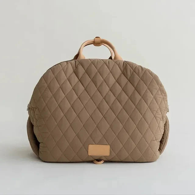 Quilted beige bag with a handle on a light gray background
